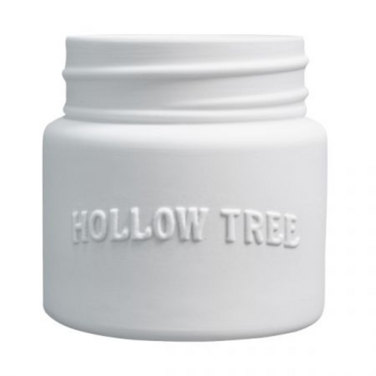A white ceramic candle jar with 'HOLLOW TREE' embossed on the front