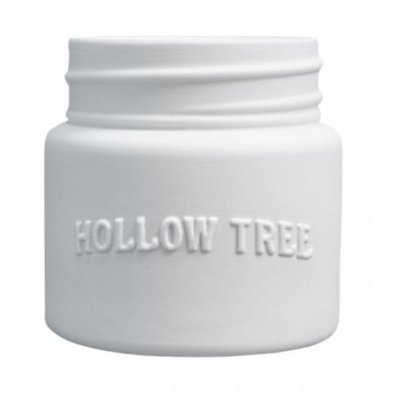 A white candle jar with 'HOLLOW TREE' embossed on the front