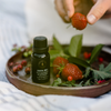 Dark green diffuser oil bottle with ribbed black cap and Wild Raspberry label