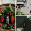 Dark glass scent bottle with Coastal Wolf label and dropper, with strawberries