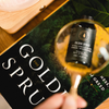 Golden Spruce diffuser oil bottle in a glass bowl, black label and cap