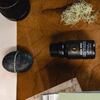 Diffuser oil bottle with black cap on a wooden surface near stones and paper