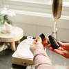 Diffuser oil bottle held in hand with black cap; label visible