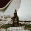 Room spray bottle, dark amber glass with gold mist sprayer cap; Lumberjack label.