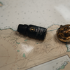Raven diffuser oil bottle on a map with a compass beside it