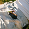 Diffuser oil bottle with black cap lying on light blue jeans fabric